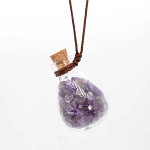 Detail of teardrop glass pendant filled with purple amethyst stones and cork stopper