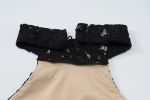 Detailed close-up of sexy black lace neckline and button on a bodycon summer dress