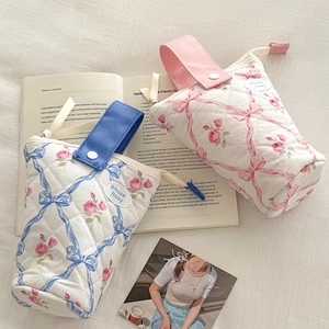 Gewatteerde etui met bloemenprint en strikaccent met handig draagbaar handvat