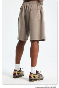 Detail view of khaki cotton sports shorts featuring an elastic waistband and back pocket