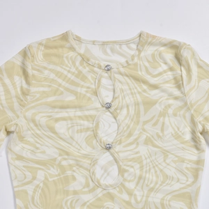 Detail of sheer mesh dress with yellow marble print, cutout front and rhinestone buttons