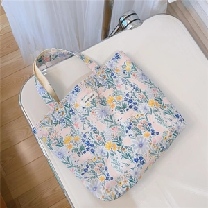 Détail d'un sac en coton à motif floral avec marguerites et étiquette tissée