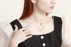 Detail of elegant gold-plated necklace featuring a hollow pendant with sparkling crystals