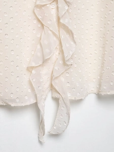 Detail der cremefarbenen Bluse mit Swiss Dot, Rüschenleiste und strukturiertem Stoff