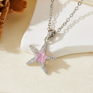Macro detail of starfish pendant with pink star zircon and white micro-pave crystals