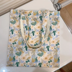 Detailed overhead view of floral cotton canvas tote bag with yellow and blue flower patterns