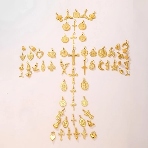 Collection of various 18K gold plated stainless steel pendants arranged in a large cross