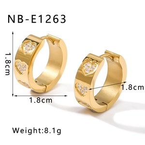 Detail of 18K gold wide hoop earrings featuring hollow heart patterns and inlaid gems