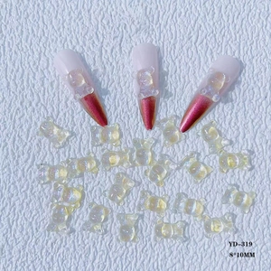 Macro shot of 3D resin bear nail charms with golden shimmer finish for DIY art
