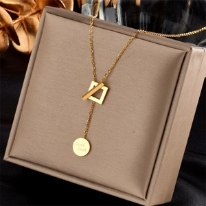 Gros plan d'un collier en Y plaqué or en acier inoxydable avec pendentif Good Luck