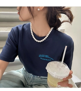 Gros plan d'un collier de perles blanches élégant et de boucles d'oreilles assorties