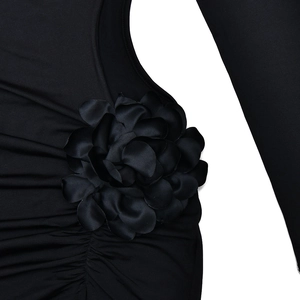 Close-up of black high neck dress featuring a 3D floral decoration and pleated texture details