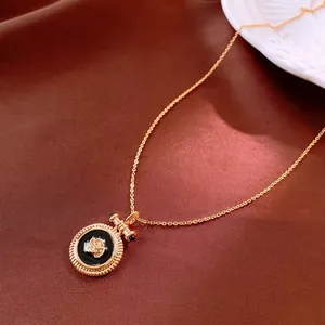Collier vintage plaqué or avec pendentif rose et émail noir sur fond de soie élégant