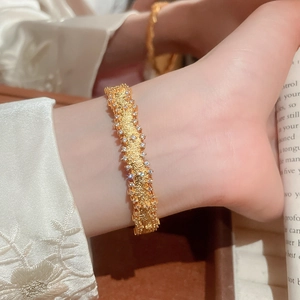 Detail view of gold cuff bracelet with frosted texture and micro-pave zircon edges