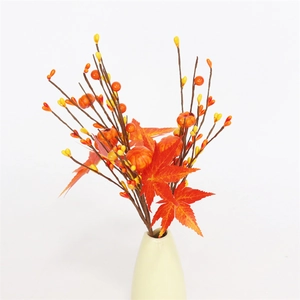 Detail of red maple leaves and mini pumpkins in a white ceramic vase for fall decor