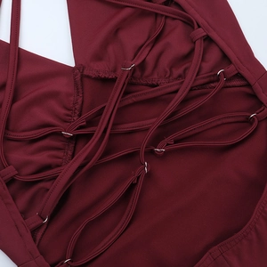 Detail of cross-back adjustable straps with silver buckles on a wine red backless dress