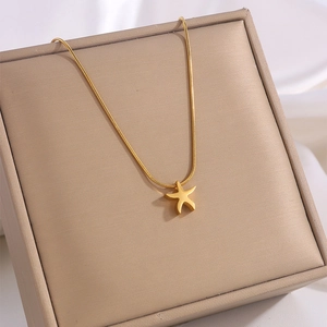 Macro shot of gold starfish pendant on a fine snake chain atop a luxury jewelry box