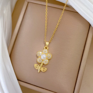 Close-up of golden flower necklace with pearl center and zircon pavé on silk
