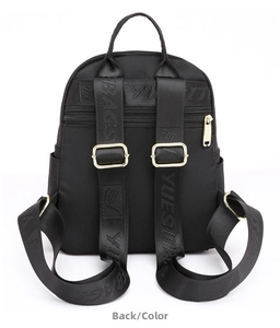 Back view of a black nylon backpack featuring woven logo straps and gold metal buckles