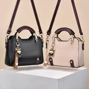 Elegant women's crossbody handbags in black and beige with cute cartoon charms
