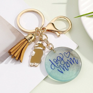 Detailed shot of dog mom resin pendant with brown tassel and corgi charm keychain