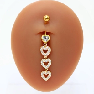 Detail of gold heart belly ring with crystals shown on a skin-tone silicone navel model