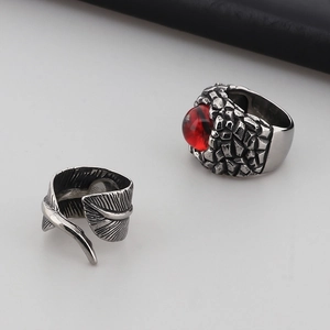 Close-up of vintage punk stainless steel rings with red gem and feather texture