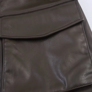 Close-up of the deep brown faux leather texture and precision stitching on the jacket pocket