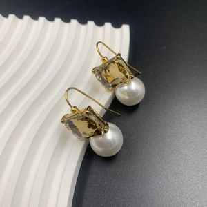 Detailed shot of vintage gold earrings with amber crystal and white round pearl drops