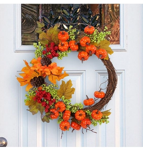 Autumn harvest door wreath with pumpkins and maple leaves on a white front door