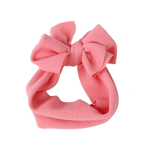 Detailed view of pink ribbed fabric baby headband with a large elastic bow decoration