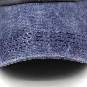 Detailed close-up of blue washed cotton baseball cap brim with four rows of stitching