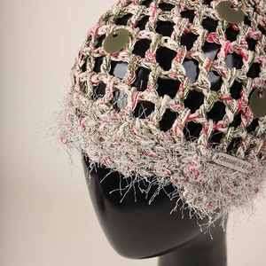 Détail d'un bonnet en maille tissé main avec paillettes argentées et franges de cils