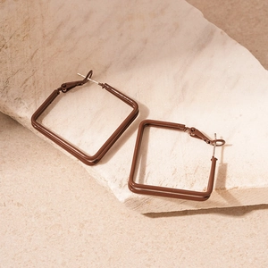 Detail shot of minimalist square hoop earrings with deep coffee matte finish on stone