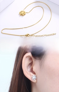 Detailed view of gold snowflake pendant necklace and silver snowflake stud earrings set