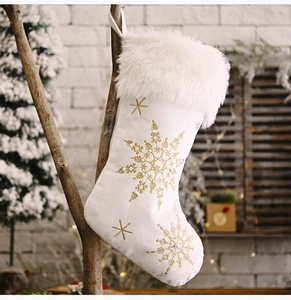 Detail of white plush Christmas stocking with gold snowflake embroidery and faux pearls
