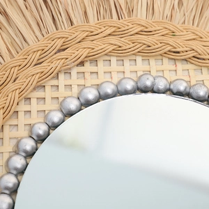 Handwoven rattan wall mirror with boho raffia fringe and silver beaded decorative frame