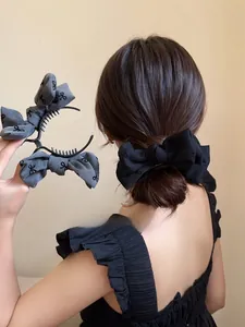 Dettaglio di fermagli per capelli con fiocco in tessuto nero e grigio per acconciature
