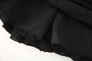 Détail de la doublure en tissu noir et des coutures soignées sur une jupe à plusieurs couches