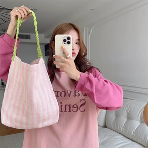 Pink and white striped canvas tote bag with green ruched handles shown in a mirror selfie