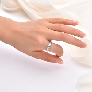 Detail showing the textured silver dragon scale ring on white satin fabric background