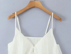 Detail of white V-neck camisole with thin straps and white front buttons
