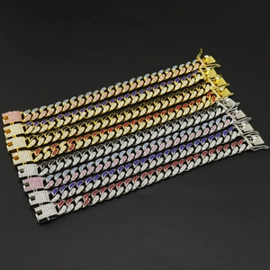 Plusieurs rangées de bracelets cubains hip hop 12mm avec strass colorés sur fond sombre