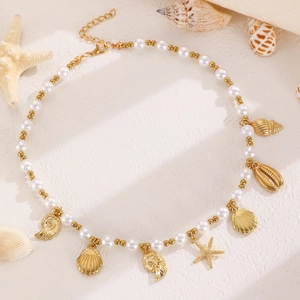 Detailaufnahme der Muschel- und Seesternanhänger an einer Perlenkette mit goldenen Akzenten