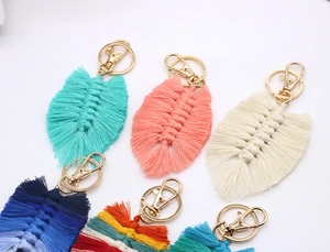 Flat lay detail of leaf-shaped woven cotton tassels in various colors with gold lobster clasps