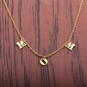 Golden stainless steel necklace featuring a MOM pendant on dark wood background