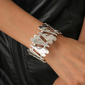 Détail macro du bracelet chaîne coeur en métal lourd avec texture argent liquide martelé