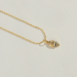 Detailed view of a 14K gold plated necklace with a shell pendant and colorful crystals