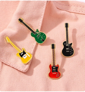 Detailed view of colorful guitar enamel pins pinned on textured pink fabric apparel