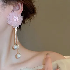 Pink mesh flower earrings with crystal tassels and pearls worn by a model